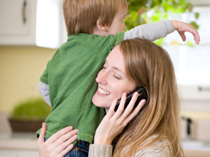 Mother on the phone holding a child